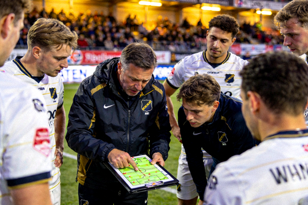 赛场边教练布置战术与球员交流的画面